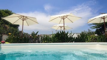 Piscine extérieure, parasols de plage, chaises longues