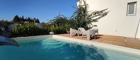 Piscine extérieure, parasols de plage, chaises longues