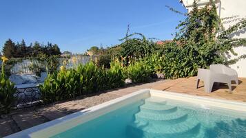 Een buitenzwembad, parasols voor strand/zwembad