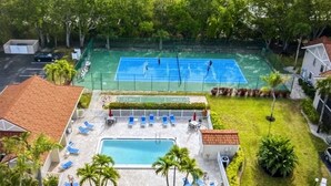 Zona residencial amb pista de tennis, piscina i gandules.