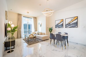 Enjoy a comfortable stay in this apartment with a spacious living area, dining table for four, and a large window offering a city view.