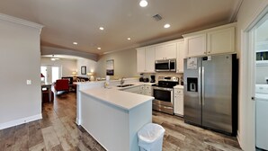 A modern kitchen with white cabinets, stainless steel appliances, and a central island. - Banana Bay Townhome #13909 by Southern Vacation Rentals (Pensacola)