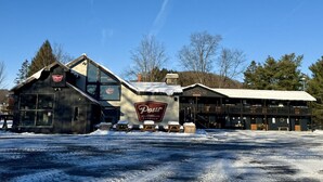 Ein Gebäude mit einem Schild 'Pour Taproom', einem großen Schaufenster und einem mit Schnee bedeckten Dach.