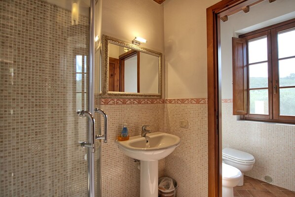 A bathroom with a shower, sink, and toilet.