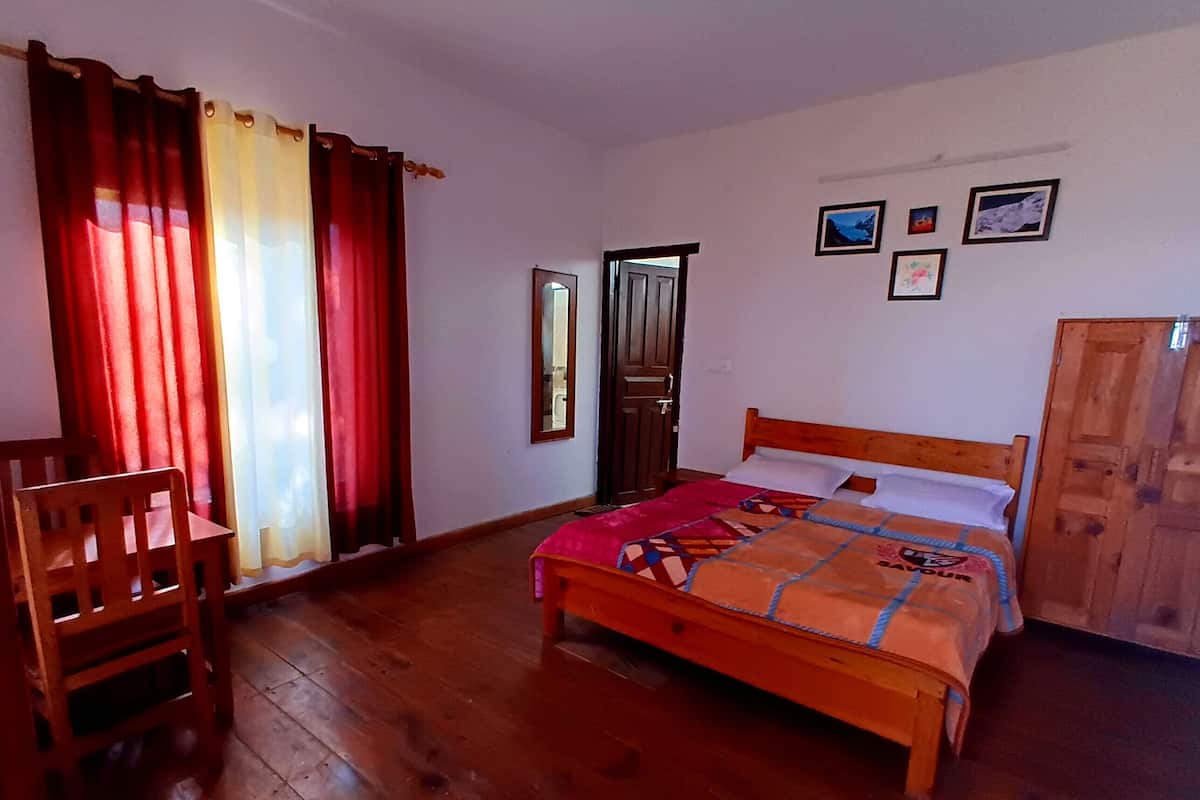 A bedroom with a wooden bed, a chair, and a wardrobe.