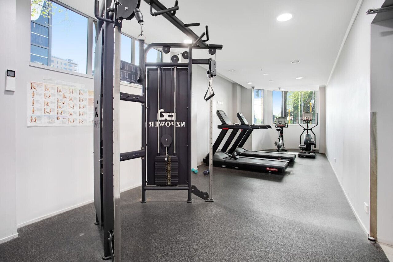 Un gimnasio con máquinas de pesas, cintas de correr y pelotas de ejercicio.