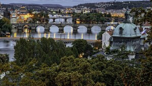 A historic cityscape with a prominent bridge, a river, and a dome-like building. - MyMozart City Center Residence: 702 (Prague)