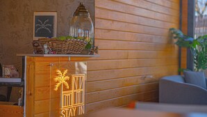 Un mur en bois orné d’un tableau encadré et d’un bocal en verre posé sur une étagère.