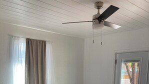 A bedroom with a bed, bedside table, and a ceiling fan. - University Casa Bonita (Tucson)