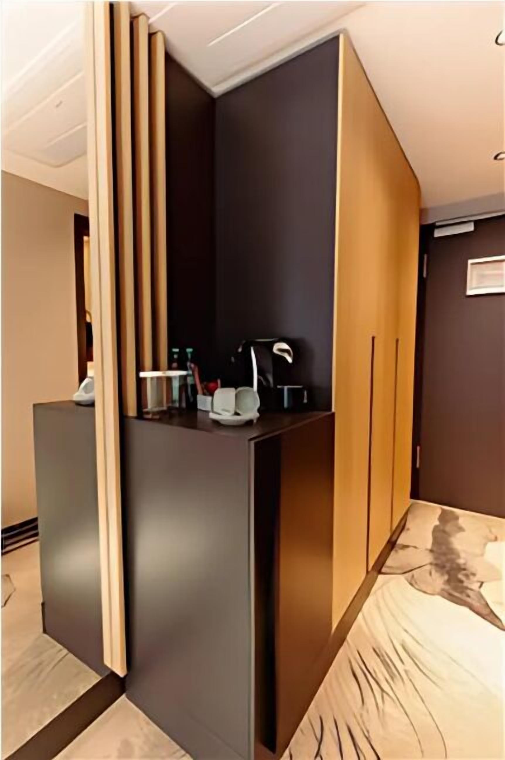 A reception area with a counter, a coat rack, and a wall-mounted clock.