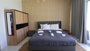 Ein modernes Schlafzimmer mit einem großen Bett, einem Kleiderschrank, einem Nachttisch und einer Pendelleuchte.