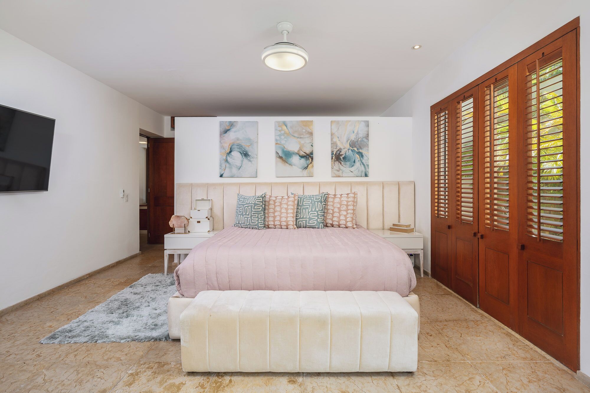 Un dormitorio con cama, mesita de noche, televisión y armario.