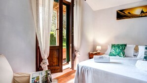 A bedroom with a bed, a nightstand, a lamp, and a painting on the wall. - Villa Sorrentina With Panoramic Terrace (Massa Lubrense)