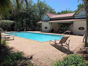 A swimming pool with lounge chairs and a covered pavilion with a red roof. - Corner Castle by Southern Vacation Rentals (Destin)