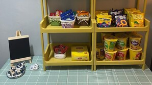 Une étagère avec divers en-cas emballés et une petite tasse en céramique.