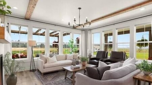 A spacious living room with a large window, a sofa, a chair, and a coffee table. - Luxe Barndominium - Mtn Views! "Hemlock" (Columbia Falls)