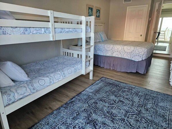 A room with bunk beds, a patterned rug, and a door leading to a balcony. - 11 - 3BR $700+ in freebies incl golf, On Beach (Miramar Beach)