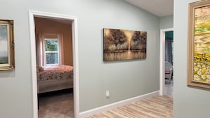 A room with a bed, a painting, and a window with curtains. - 5 BR King Beds Game Room Yard Family Home Explore DC Quantico Stafford  (Stafford)
