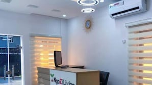 A reception desk with a logo, a clock, and an air conditioning unit on the wall. - Studio(S7) @ LEKKI PHASE 1. 24/7 AC. By NgoZiLiving


 (Lekki, phase 1)