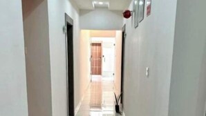 A corridor with white walls, a tiled floor, and recessed lighting. - Studio(S7) @ LEKKI PHASE 1. 24/7 AC. By NgoZiLiving


 (Lekki, phase 1)