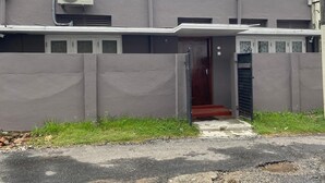 A building with a grey facade, a red door, and a small entrance with steps. - AC Home in Wellawatta Colombo 06 - 2AC Bedrooms & Servant/Guest room (Colombo)