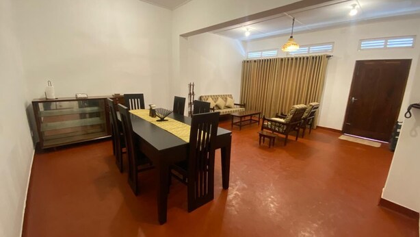 A spacious room with a dining table and chairs, a sofa set, a ceiling fan, and a door. - AC Home in Wellawatta Colombo 06 - 2AC Bedrooms & Servant/Guest room (Colombo)