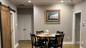 A dining area with a round table, black chairs, and a framed picture on the wall. - Cajun Country Escape  (Gonzales)