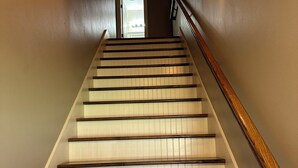 A staircase with wooden steps and a handrail, leading to a door at the top. - Cajun Country Escape  (Gonzales)