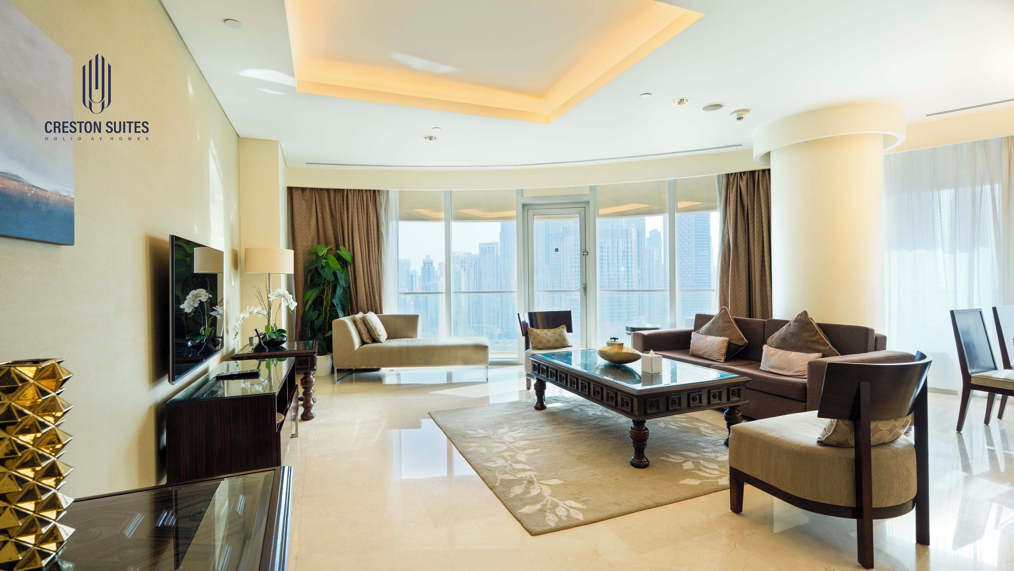 A modern living room with a sofa, coffee table, and TV, large windows with a city view, and a glass partition.
