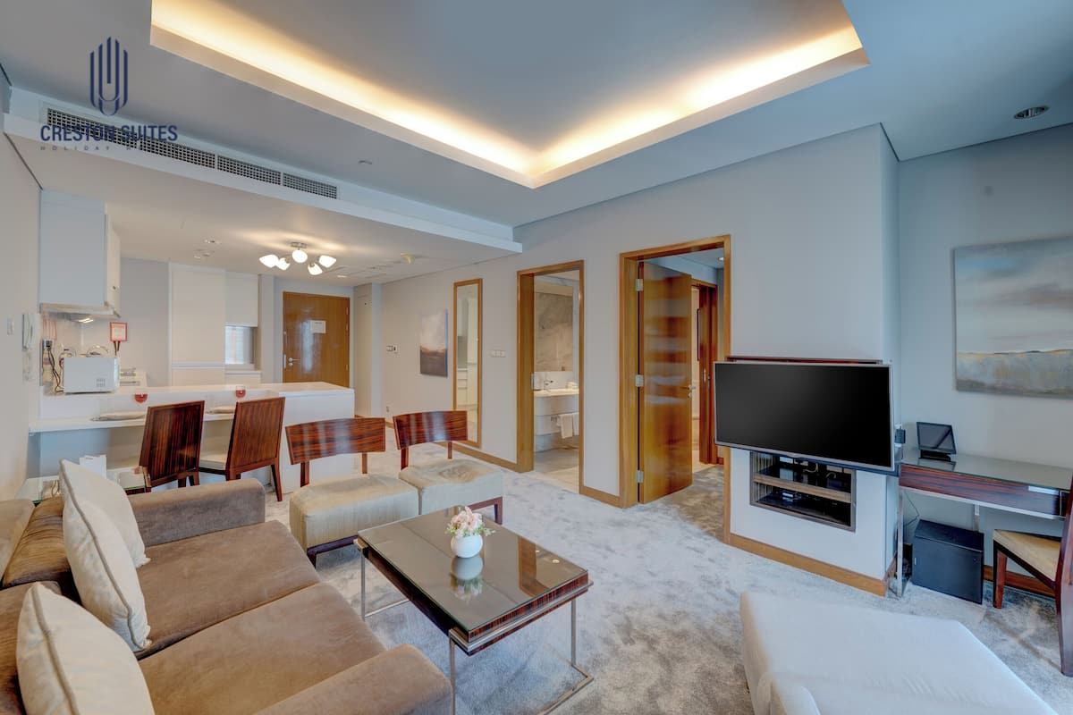 A modern hotel room with a living area, a dining space, and a bathroom.