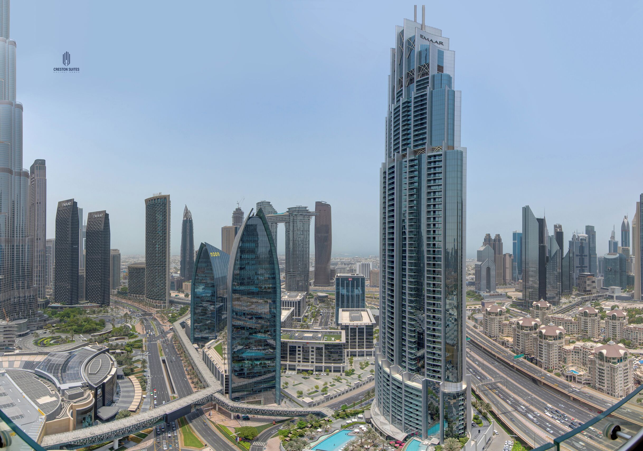 Un immeuble de grande hauteur doté d’une façade moderne en verre et d’une enseigne « EMAAR » bien visible.