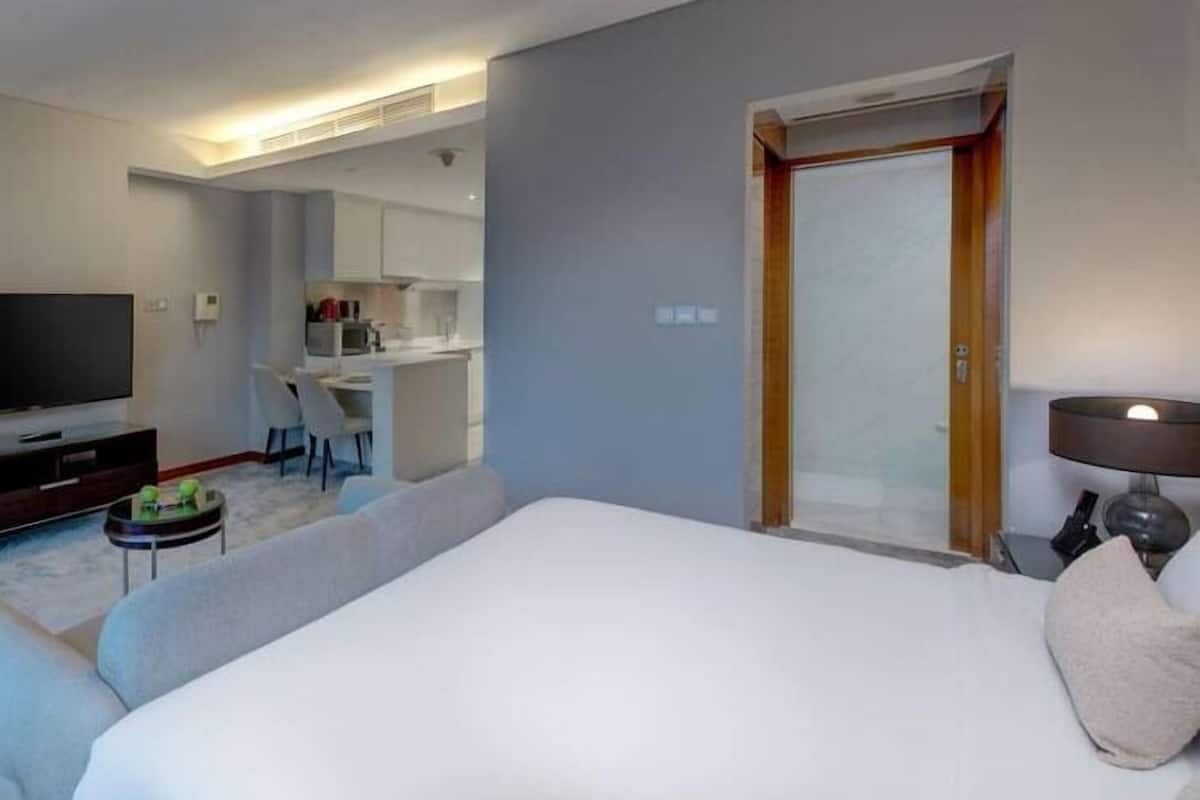 Relax in a spacious room with a large bed, flat-screen TV, and compact kitchenette.