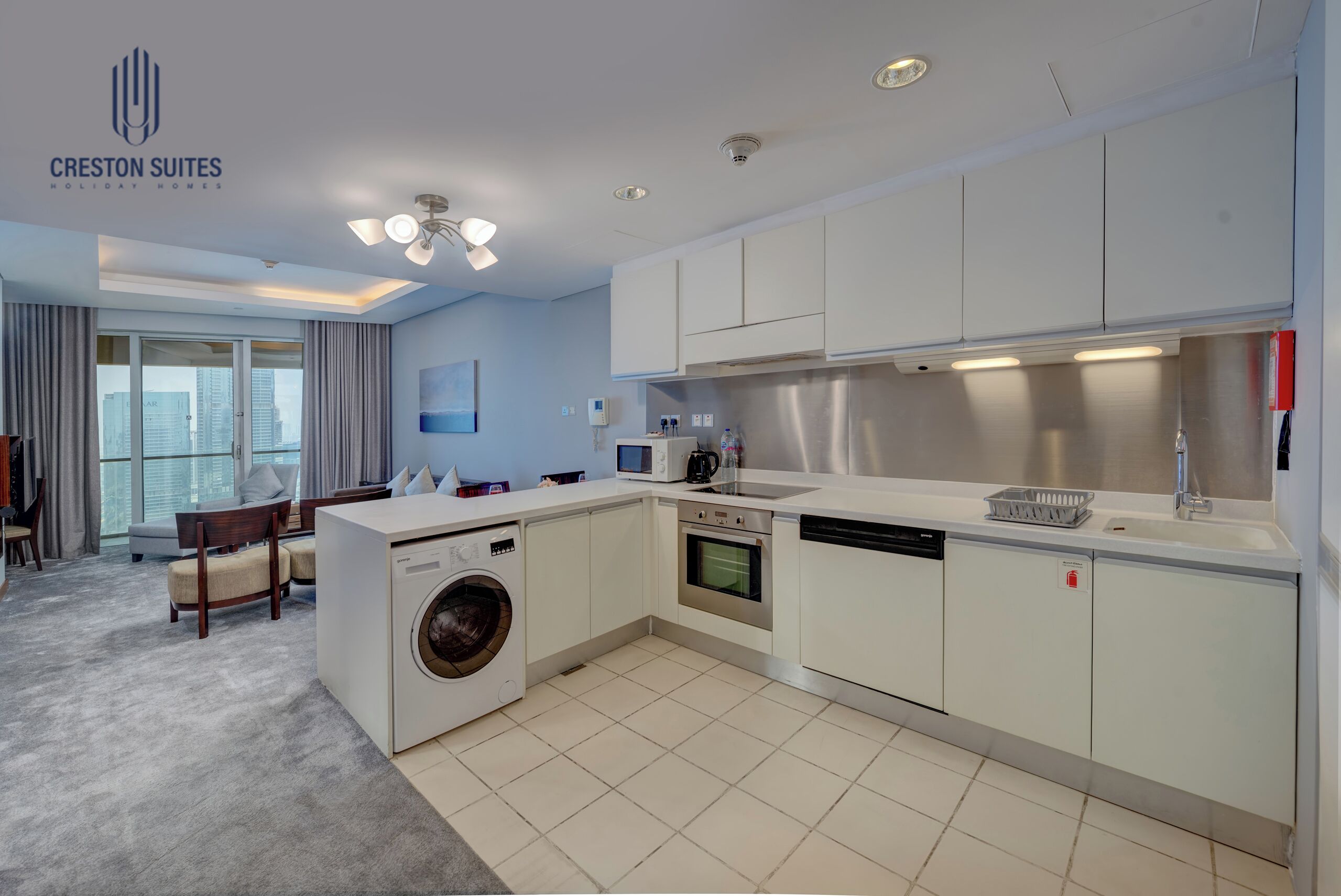 Eine moderne Küche mit integriertem Waschmaschine, Backofen und Geschirrspüler, einem Essbereich mit Blick und einem großen Fenster.