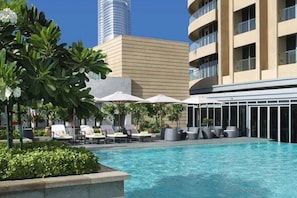 Relax by the pool surrounded by comfortable lounge chairs and lush greenery.