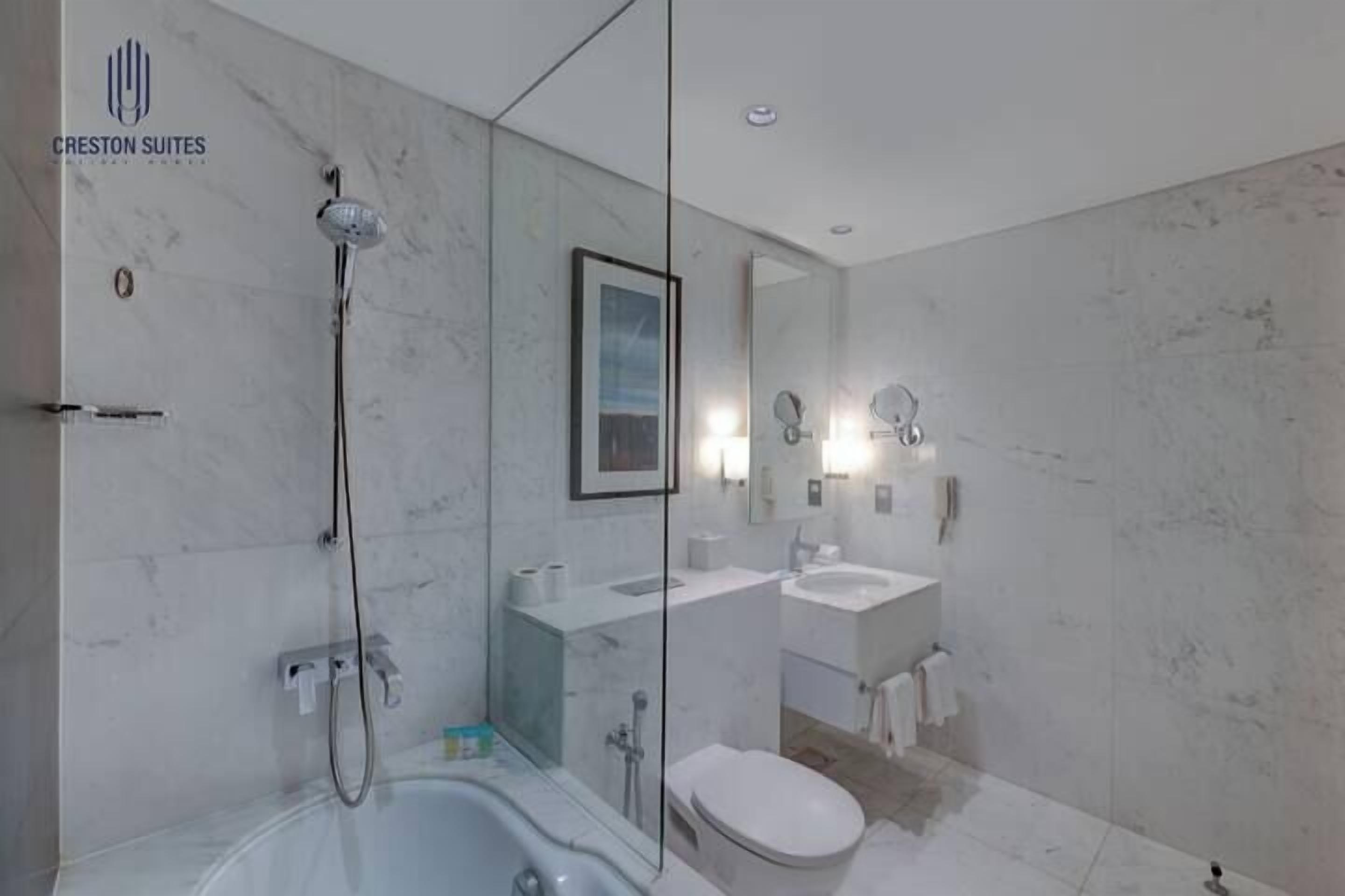 A modern bathroom with a bathtub, shower, and toilet.