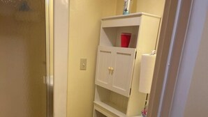 Une petite salle de bain avec des toilettes, une douche et un lavabo.
