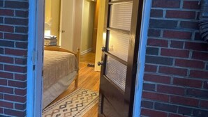 Une porte qui mène à une pièce où se trouvent un lit et un tapis à motifs.