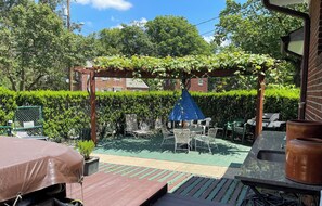 A patio area with a pergola covered in vines, outdoor furniture, and a barbecue grill. - TWIN BED -  PILLOW - SHOWER - FRIDGE - MW - 66 Night (Silver Spring)