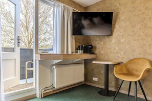 A room with a bunk bed, a television, a small table, a chair, and a radiator. - Hotel de Zon anno 1870 (Oosterwolde)