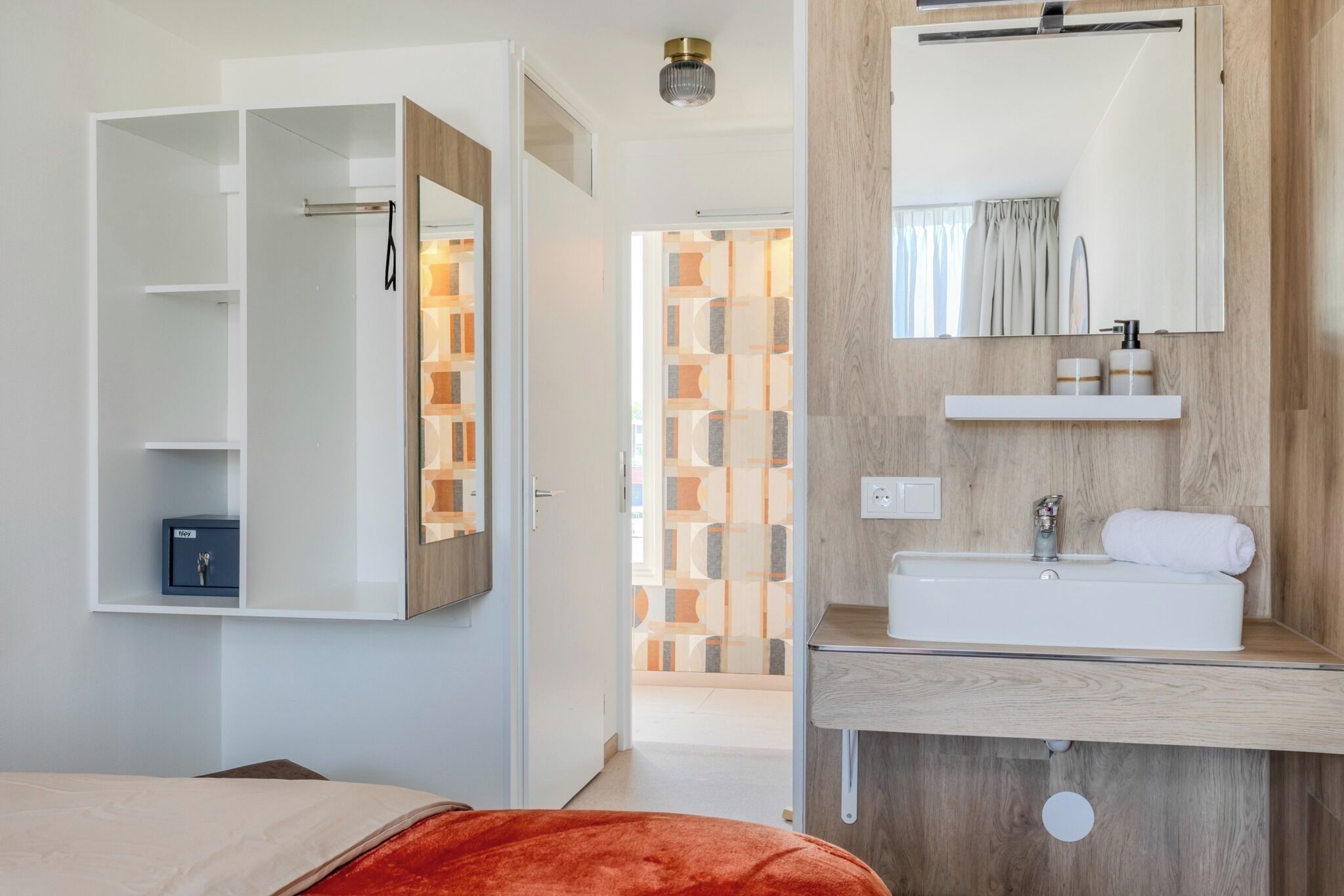 Une salle de bain moderne avec un meuble-lavabo en bois, un miroir et un espace douche.