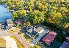 An aerial view of a residential area with houses, a dock, and a lake.