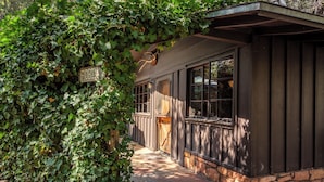 A rustic building with a wooden exterior, a stone foundation, and a covered porch area. - Briar Patch Inn (Sedona)