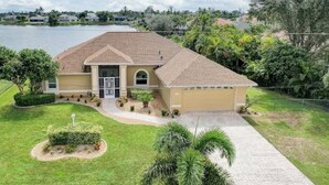 A single-story house with a paved driveway, a garage, and a well-maintained lawn.