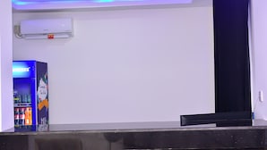 Ein Empfangsbereich mit modernem Deckenstil, der mit LED-Beleuchtung, einer Wand-Klimaanlage und einem Getränkeautomaten ausgestattet ist.