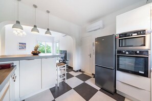 A modern kitchen with a black and white checkered floor, stainless steel appliances, and pendant lighting. - Villa 10 mn walk from the center, the beaches the TGV station of Saint‑Raphaël (Saint-Raphaël)
