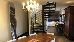 Una cocina moderna con una isla de madera, una escalera en espiral y un candelabro.