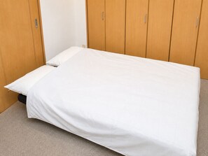A single bed with a white mattress and pillow in a room with wooden panel walls. - SLEEPLAB THE STAY Casual Shinjuku (Tokyo)