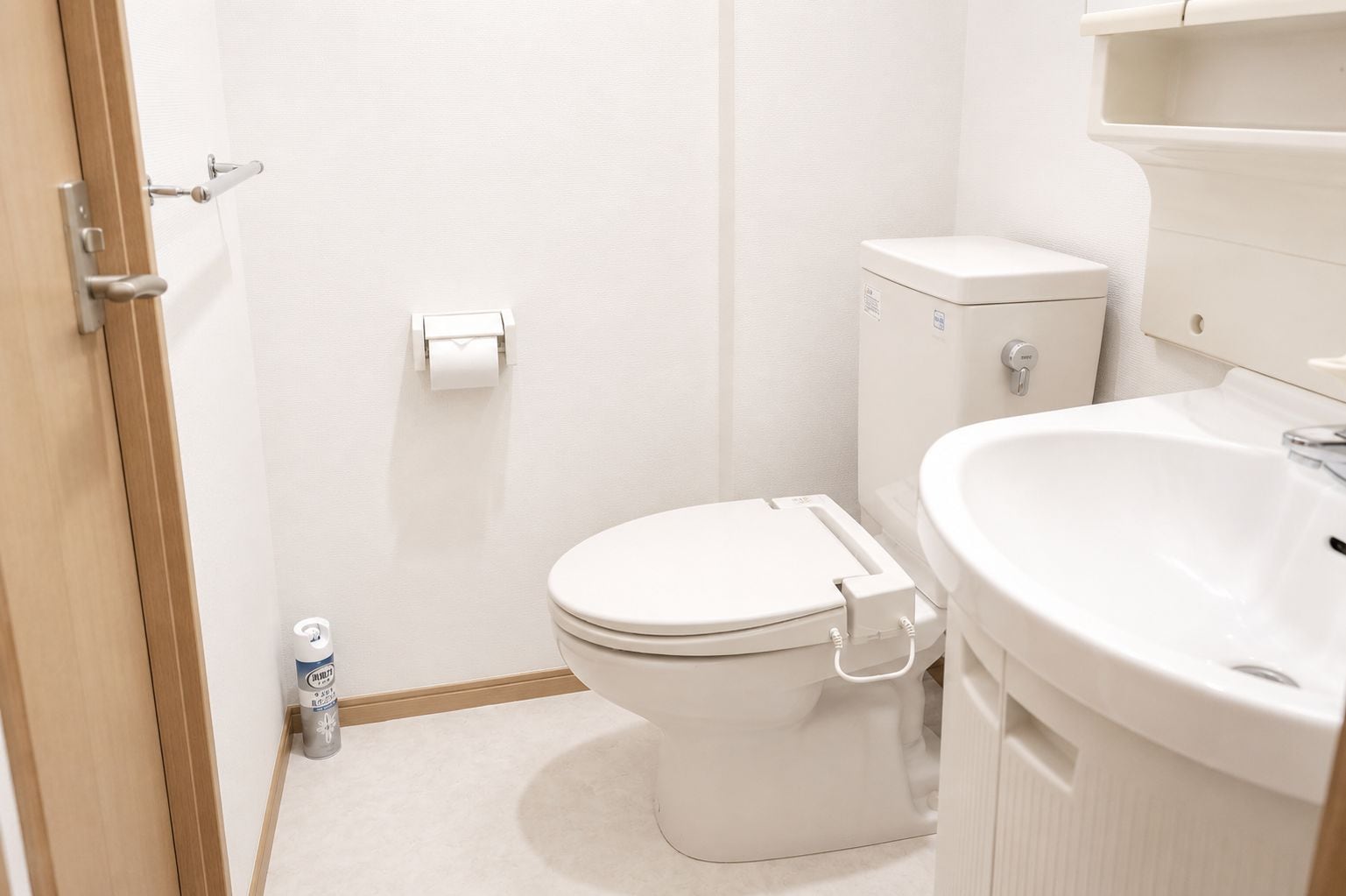 Une salle de bain équipée de toilettes, d’un lavabo et de papier toilette.