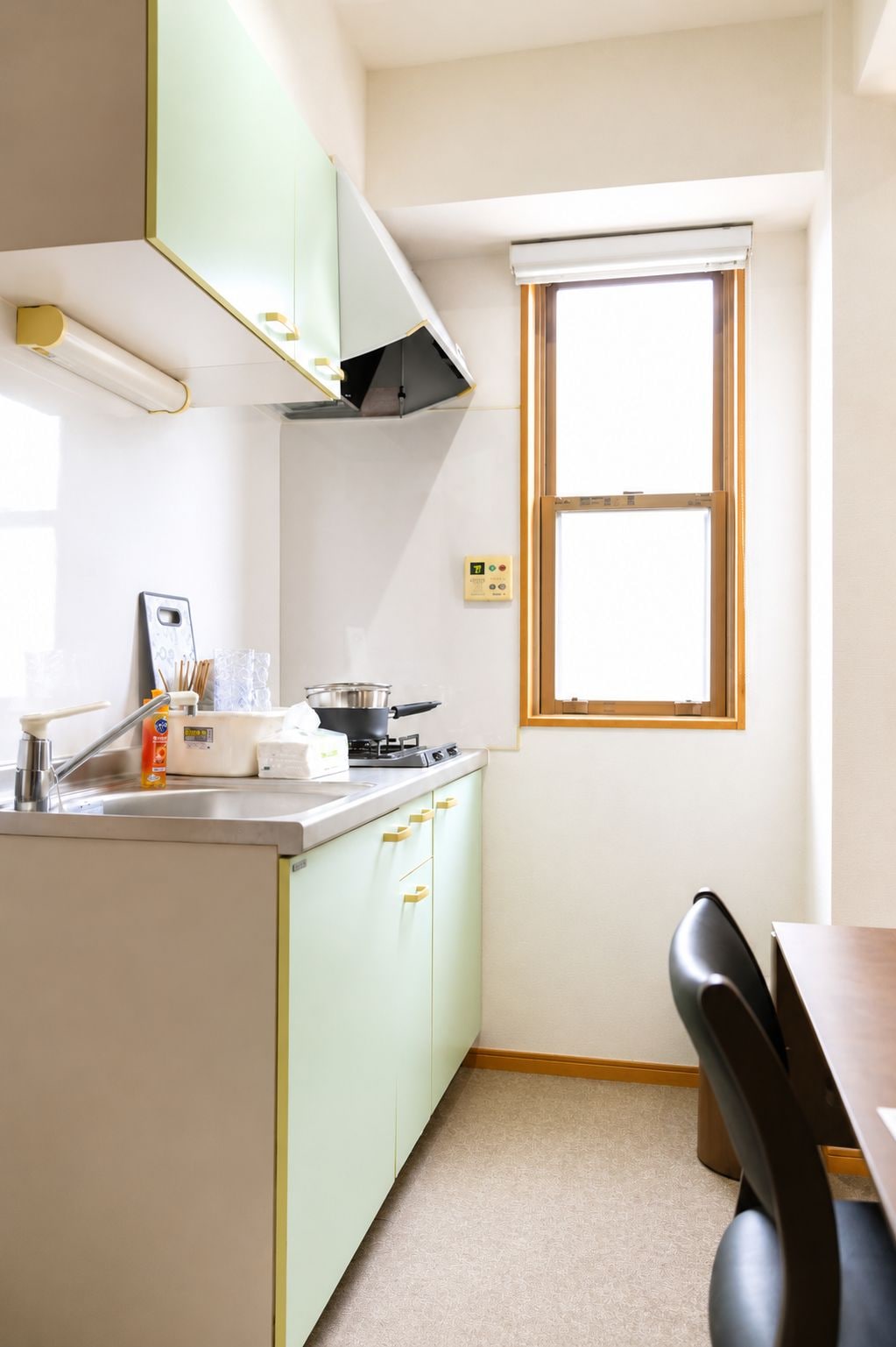 A compact kitchen with a window, a stove, and a sink.