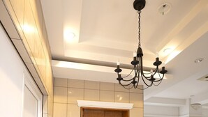 Un ascenseur moderne avec des finitions en bois, un mur recouvert de carreaux blancs et un lustre.